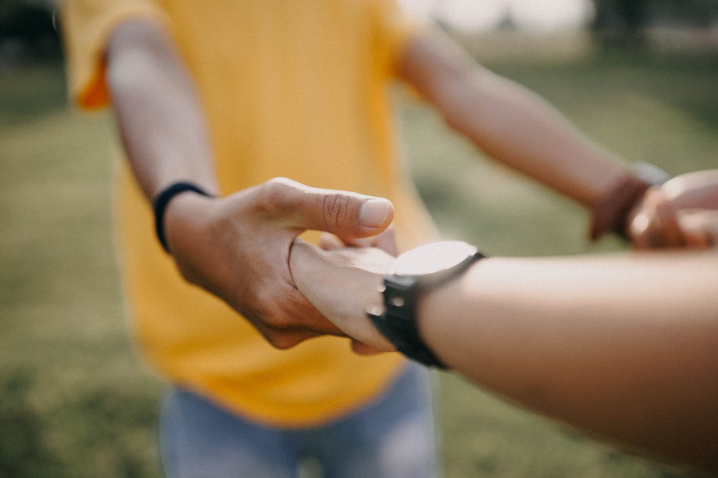 Two people gently holding hands
